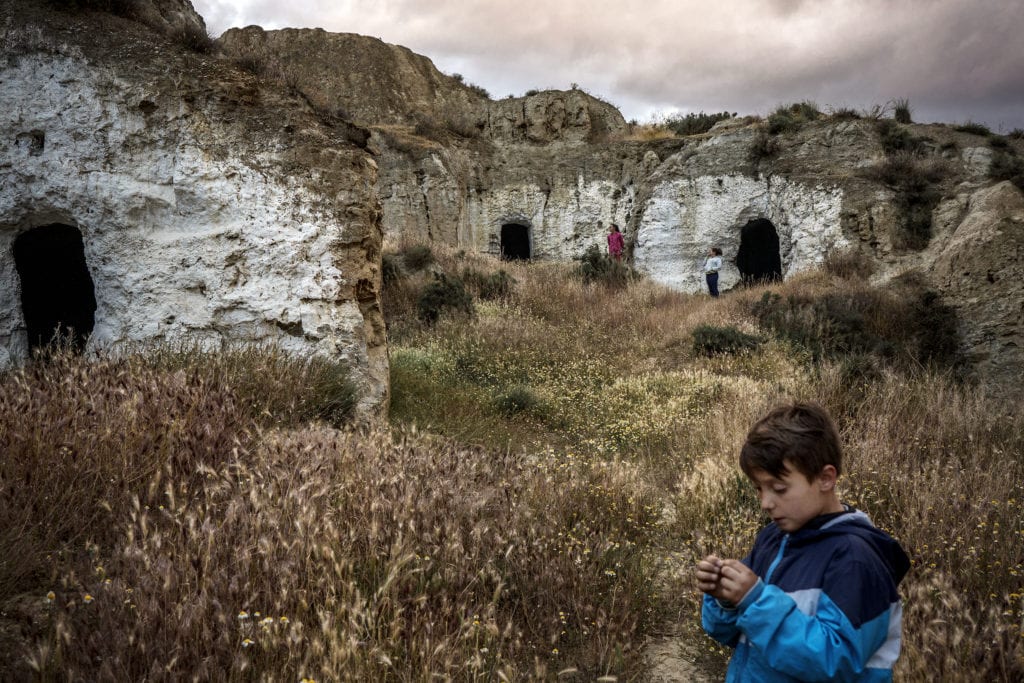 Des enfants jouent dans une grotte abandonnée. Auparavant, toutes les grottes étaient occupées, mais de nombreux résidents ont quitté le village.