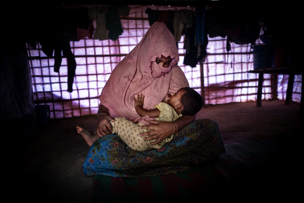 COX BAZAR, BANGLADESH- SEPT, 2018: (Faux prénom) Taslima (30) a été violée par les soldats Birmans en août 2017 alors qu'elle était enceinte de son mari. La famille arrive au camp, son mari l'a abandonnée. Elle a mis au monde Shushuma âgée de 6 mois, seule. Tous les voisins pensent qu'elle est le fruit du viol et la stigmatise. Ils ne veulent pas que Shushuma s'approche d'eux. Talsima se retrouve isolée. 