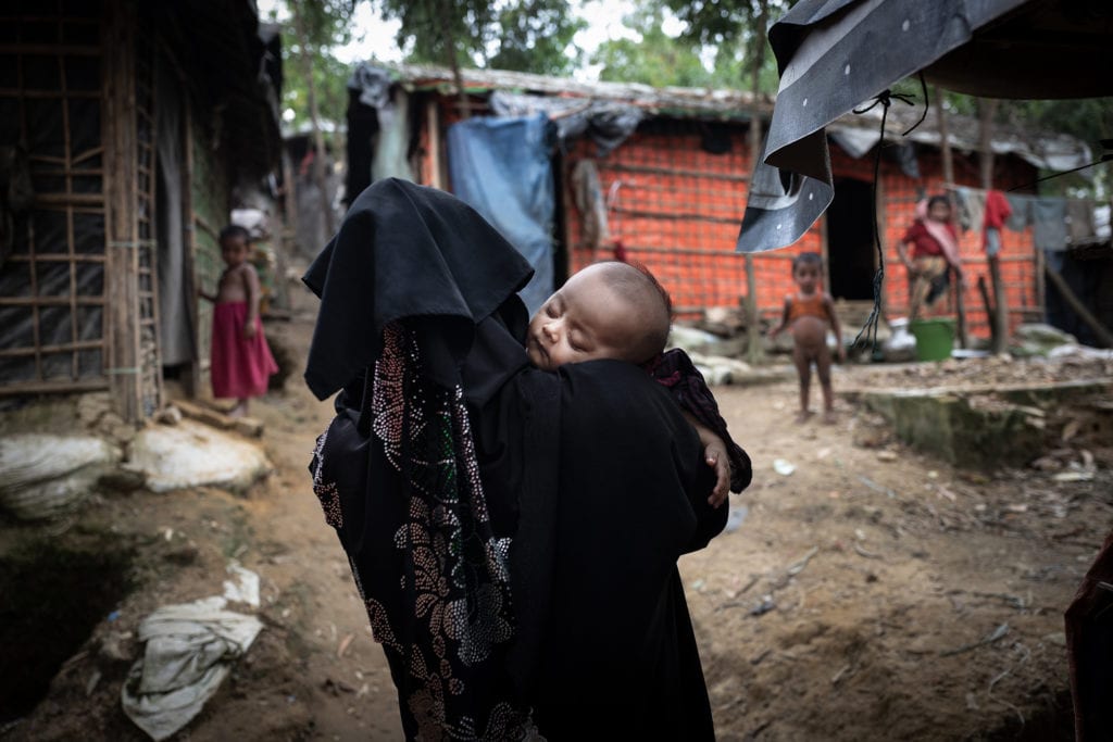 COX BAZAR, BANGLADESH- SEPT, 2018: Yasmine agée de 4 mois s'est endormie dans les bras de sa mère Shafiqa (20). Yasmine a la peau claire et les traits un peu bridés. Elle est le fruit du viol de sa mère par les soldats birmans le 24 aôut 2017. Shafiqa a réussi à convaincre son mari de la garder et de faire comem si elle était sienne. Elle est tolérée dans la famille, mais le secret doit être gardé à tout prix pour que Yasmine ne soit pas stigmatisée et rejetée par la communauté Rohingya qui a des problèmes avec ces bébés de la honte appelé - fils de Birmans-.  