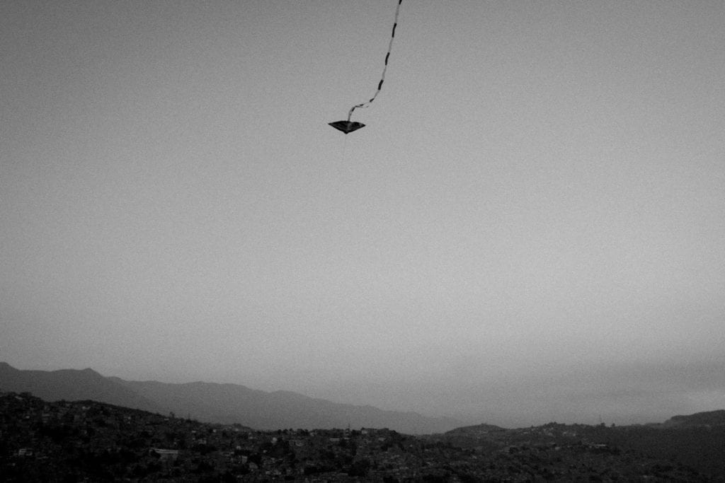 A kite flies on top of Petare, the biggest "barrio" (slum) in Caracas and second largest in Latin America on March 2016. Kids have the tradition of flying kites inside the barrios of my city. From the series Blurred in Despair.
