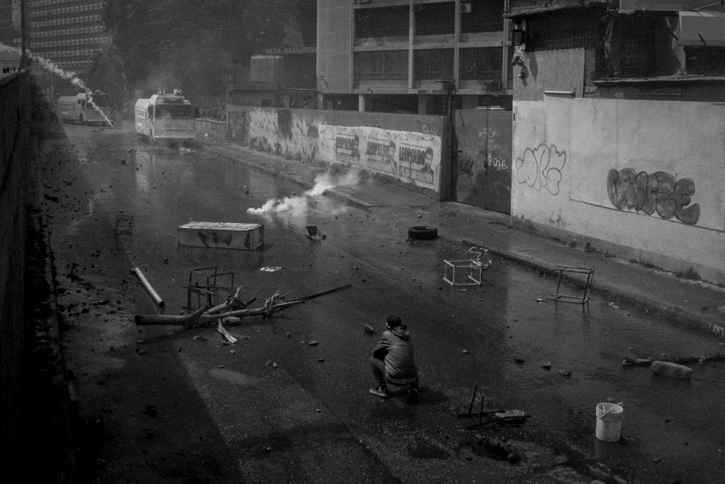 A young protester waits for the water canon to come to him during an opposition demonstration that ended up in a 4 hour confrontation with the security forces in Caracas, April 6, 2017.