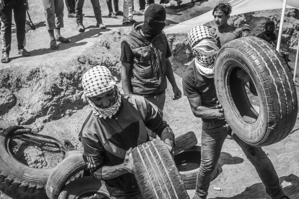 SHEJAIYA, GAZA: Des "shebabs" préparent des pneus pour les brûler lors de la manifestation de vendredi au camp de Malaka, le 11 mai 2018. Le 30 mars, les Palestiniens de Gaza ont décidé de lancer le mouvement "Grande marche du retour" qui se déroule sous forme de sit-in et camps à la frontière avec Israël jusqu'au 15 mai, date de la Nakba, afin de réclamer leur droit de retour. 