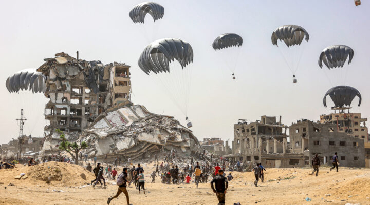 People rush to landing humanitarian aid packages dropped over the northern Gaza Strip on April 23, 2024 amid the ongoing conflict in the Palestinian territory between Israel and the militant group Hamas. (Photo by Omar AL-QATTAA / AFP)